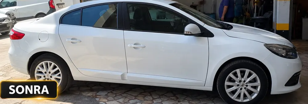 Renault Fluence – yan ve ön hasar: Renault Fluence yan kapı, çamurluk ve ön tampon hasarı onarılmış beyaz otomobil – onarım sonrası